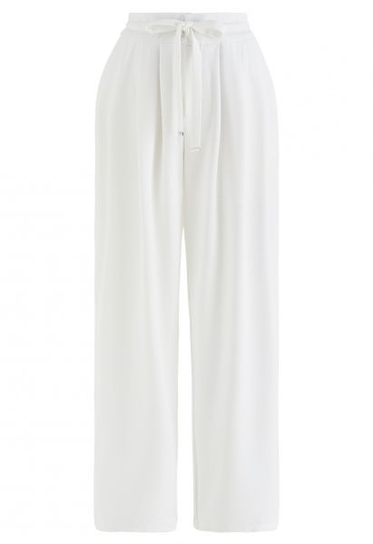 Pantaloni bianchi a gamba larga con coulisse in vita e dettagli plissettati