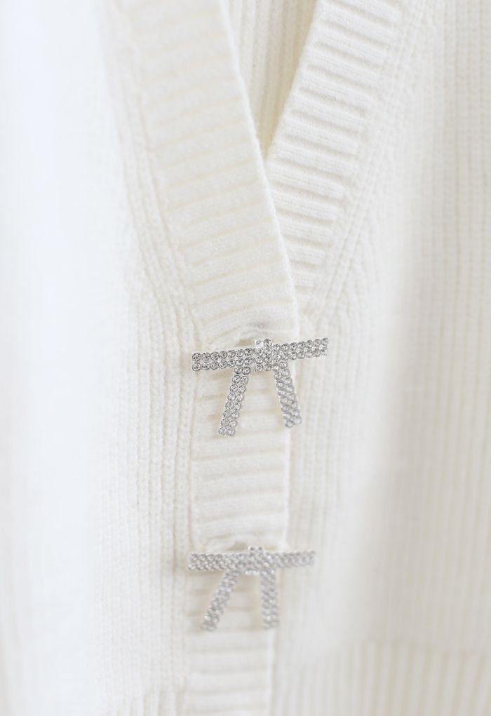 Cardigan in maglia corta con bottoni e spilla con fiocco in bianco