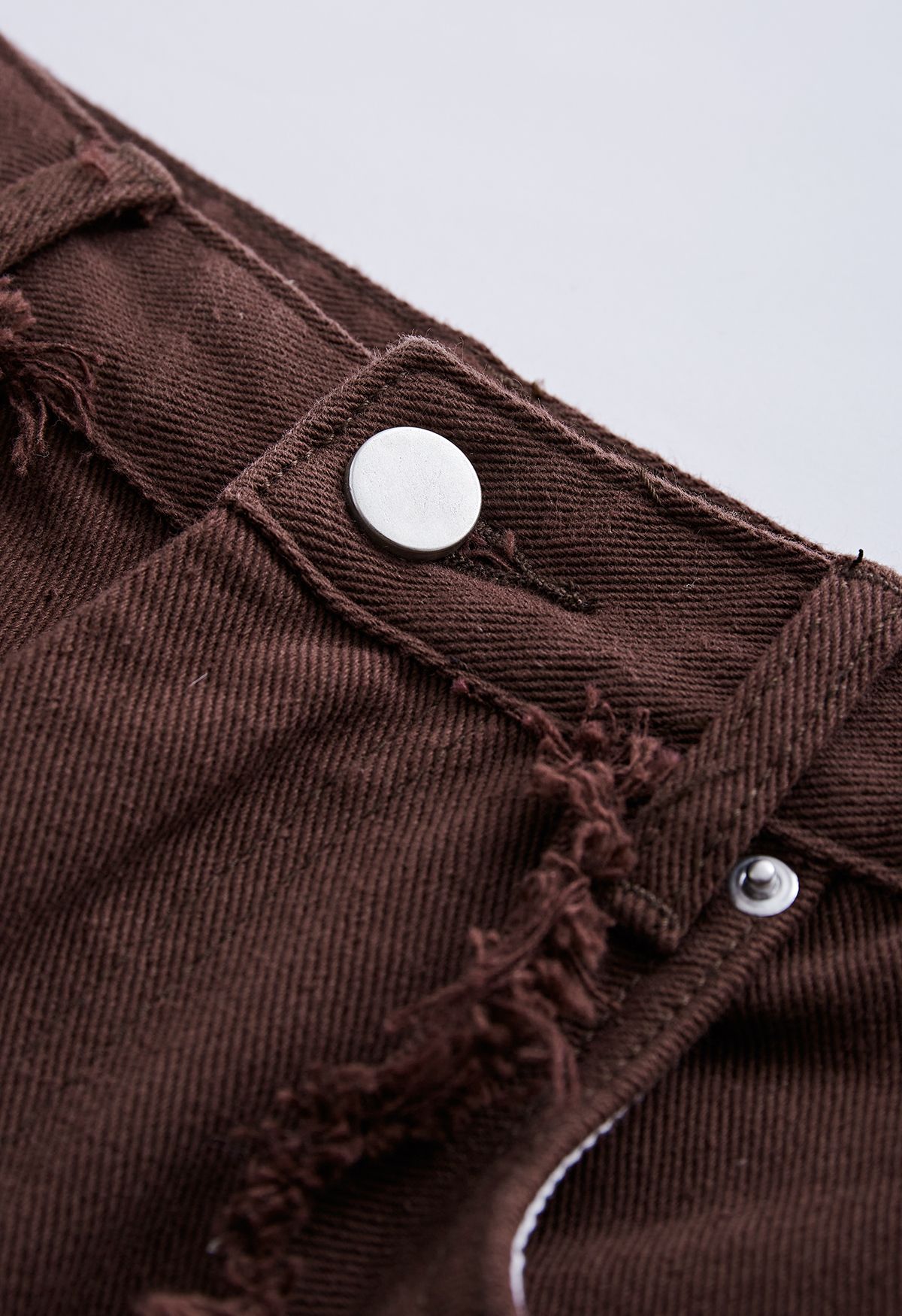 Jeans svasati classici con tasche e dettagli sfrangiati in marrone