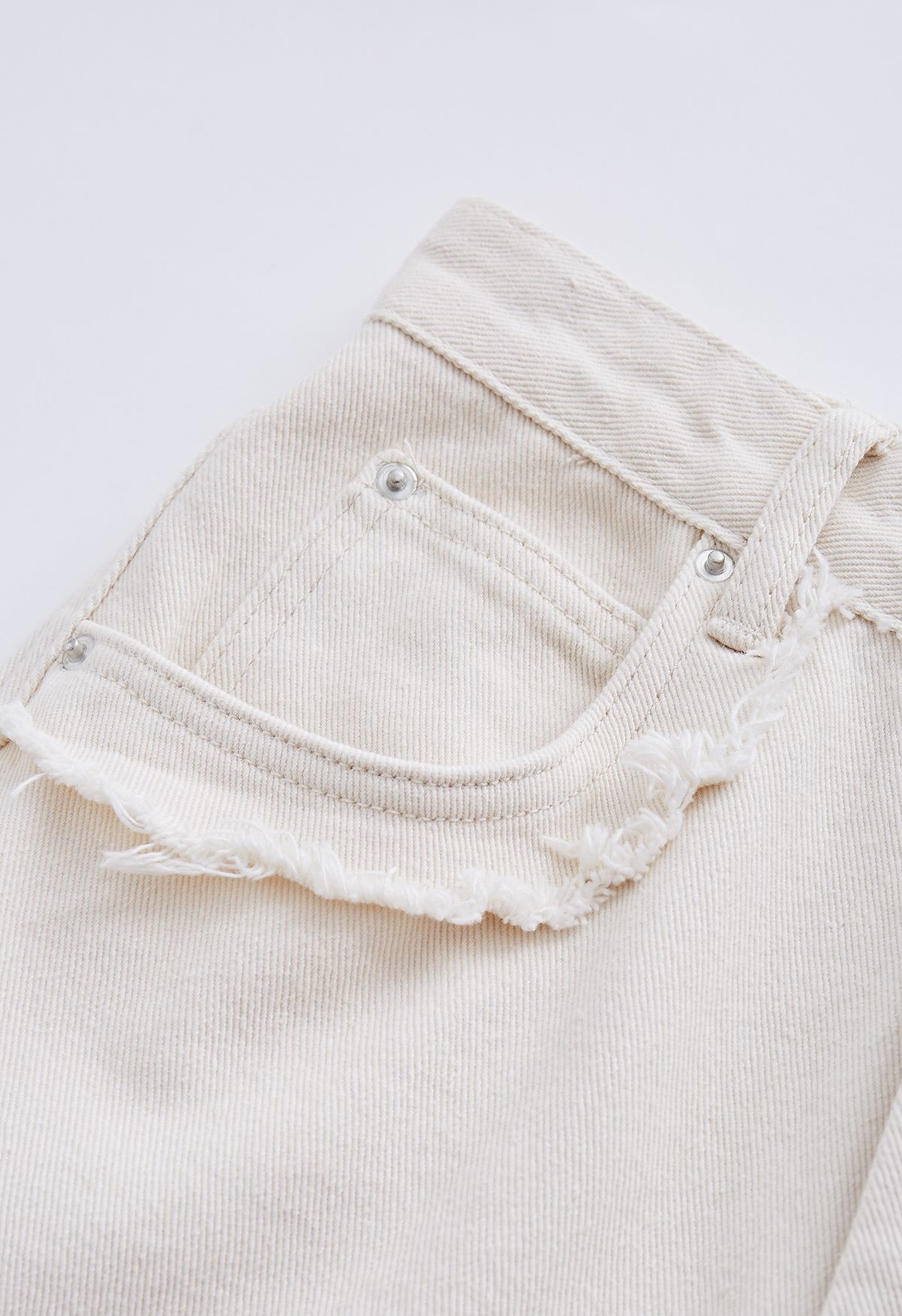 Jeans svasati classici con tasche e dettagli sfrangiati in avorio