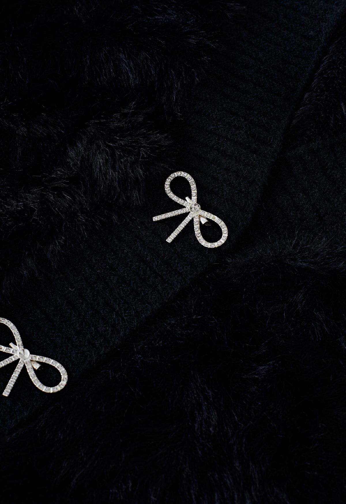 Cardigan in maglia sfocata con spilla con fiocco di diamanti in nero