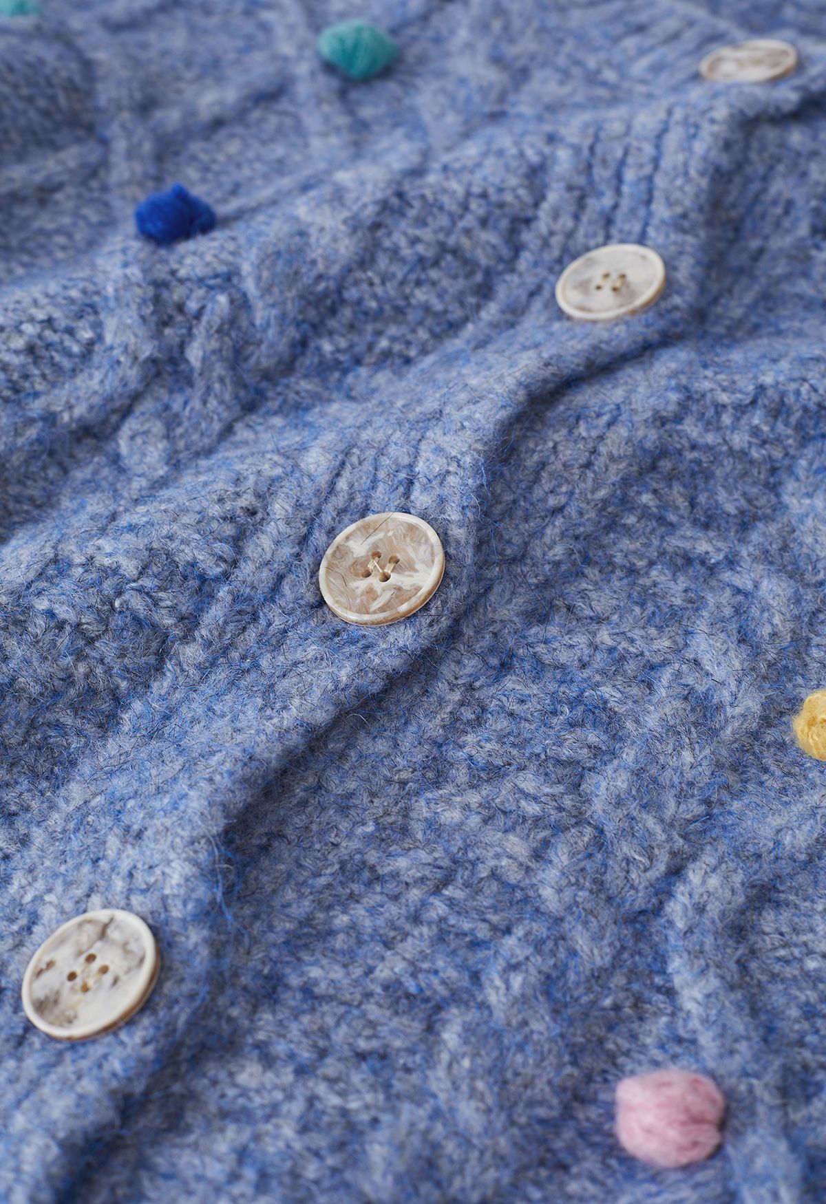 Cardigan in maglia a rombi con pompon colorato in blu