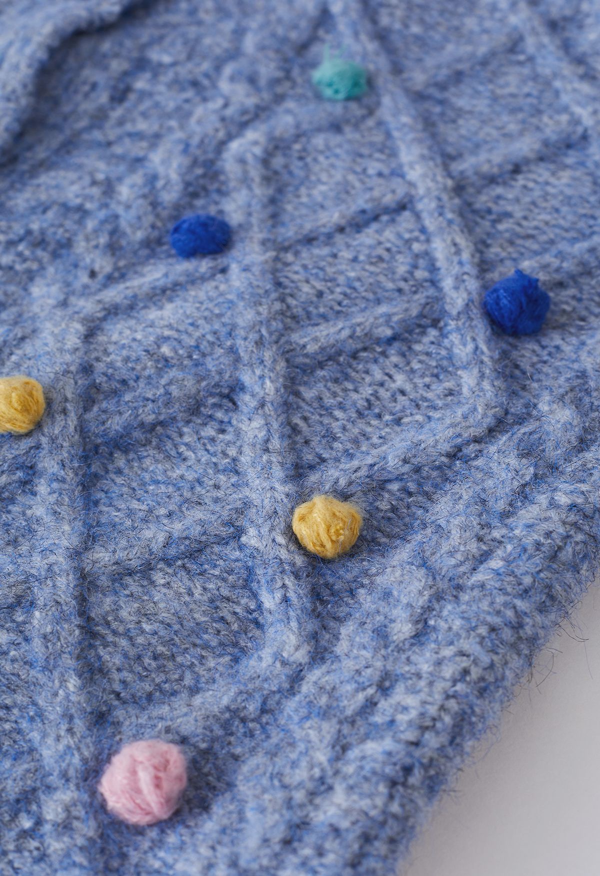 Cardigan in maglia a rombi con pompon colorato in blu