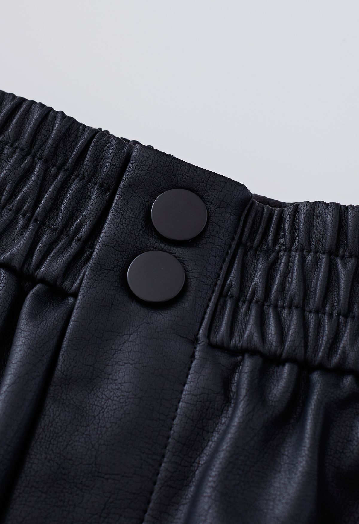 Pantaloncini in finta pelle con bottoni testurizzati in nero