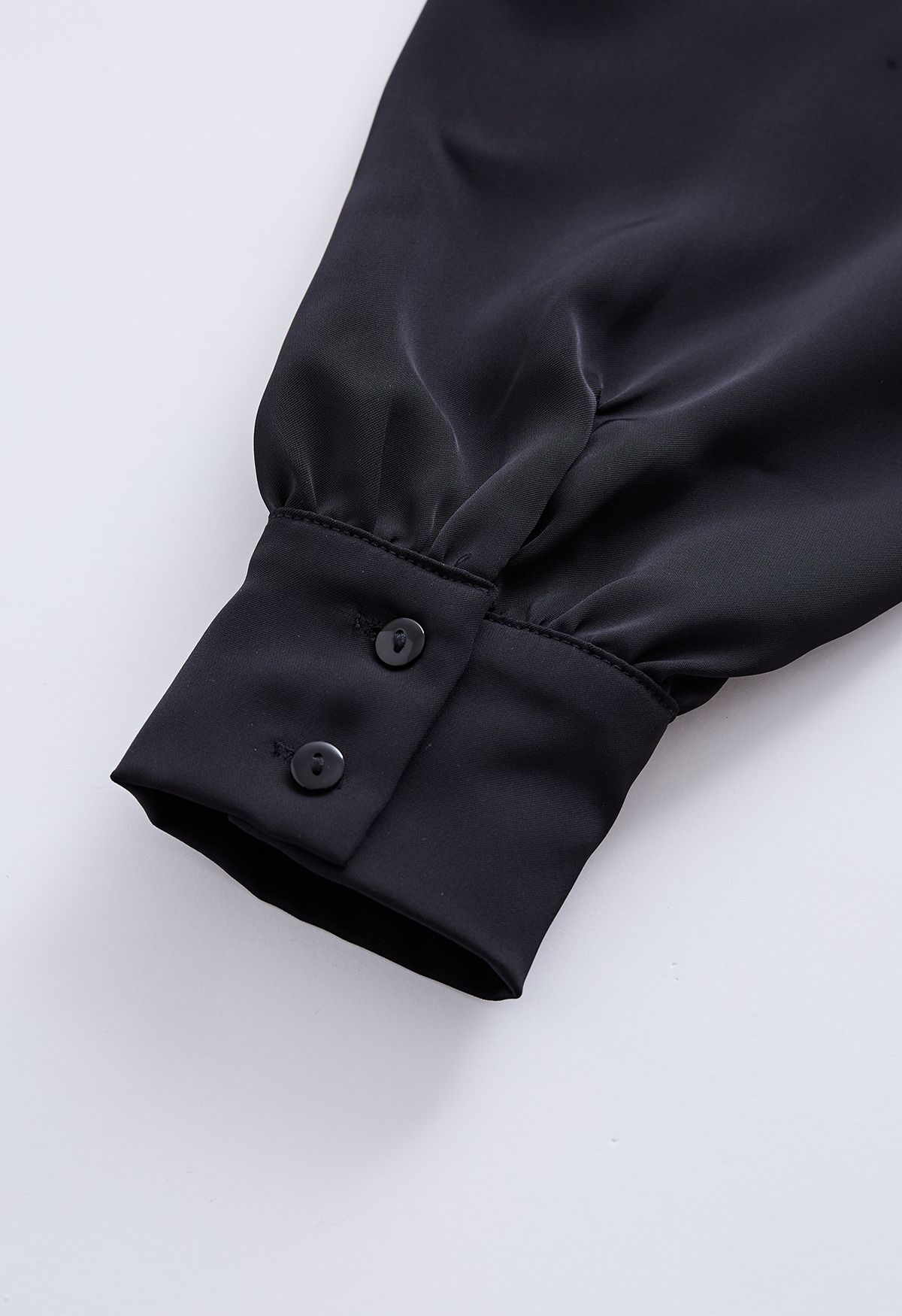 Top asimmetrico in raso con drappeggio a spalla fredda in nero