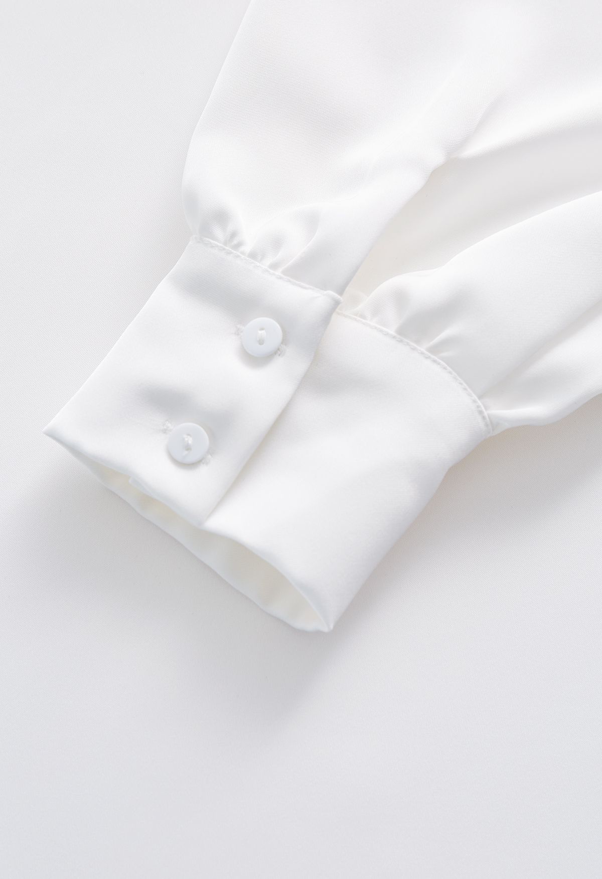 Top asimmetrico in raso con drappeggio a spalla fredda in bianco