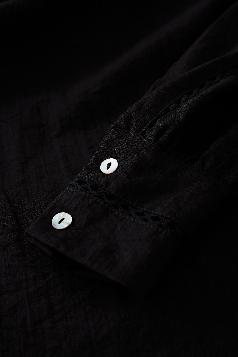 Camicia con nappe scavate e minigonna a strati in nero