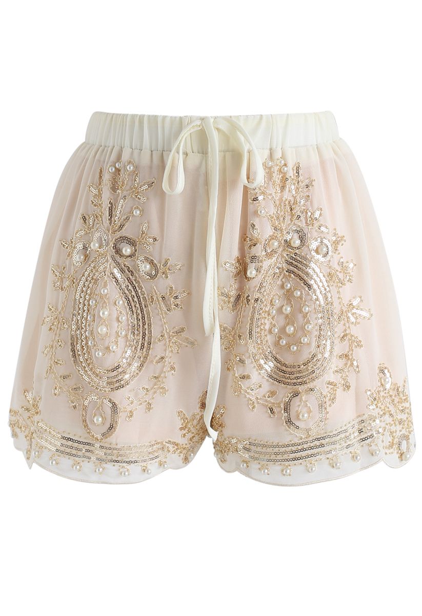 Perle lucenti che rifiniscono gli shorts in chiffon color crema