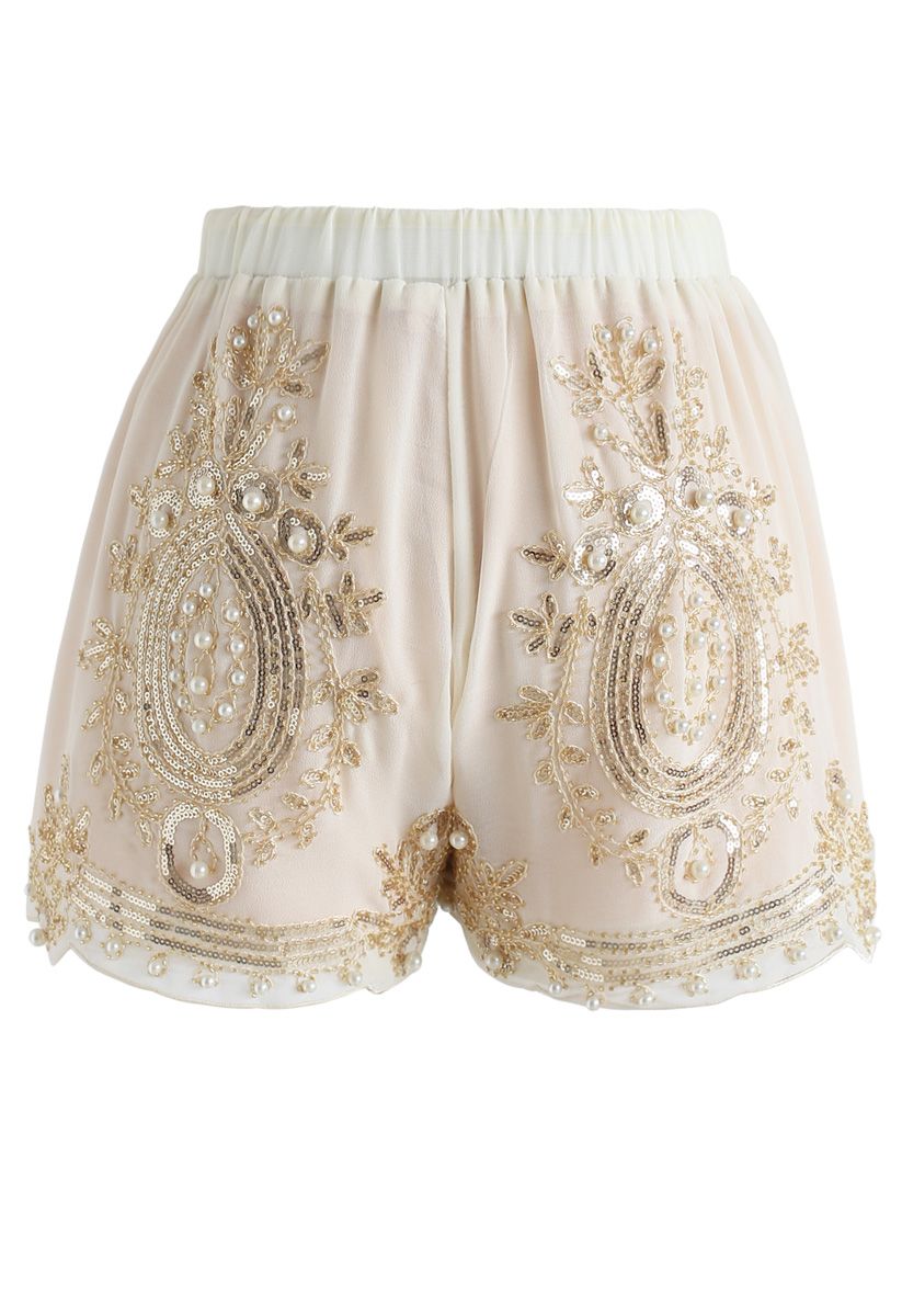 Perle lucenti che rifiniscono gli shorts in chiffon color crema